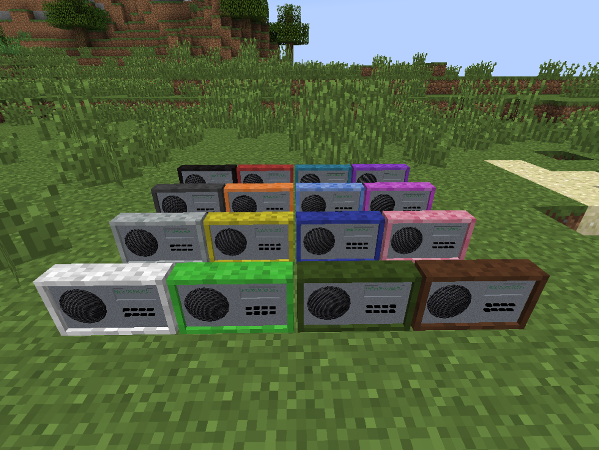 Minecraft tem rádio integrada - Uma coleção de diferentes blocos de rádio coloridos em um ambiente de jogo, exibindo as várias cores disponíveis no Minecraft, em destaque em um campo verde.