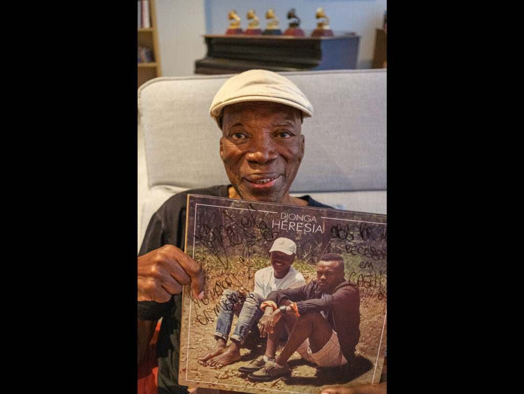Milton Nascimento segurando o disco Heresia de Djonga, lançado em 2017, no qual ele recria a capa do clássico álbum Clube da Esquina