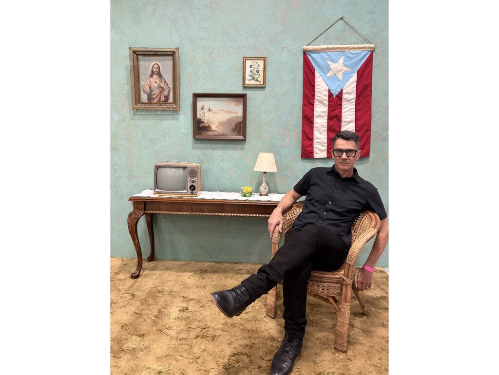 Carlos Taran tira foto próximo à bandeira de Porto Rico